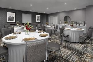 una sala da pranzo con tavoli e sedie con fiori di Homewood Suites by Hilton San Antonio Riverwalk/Downtown a San Antonio