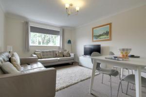 a living room with a couch and a table at The Firs - Apartment next to Beach & Forest - Pets are free in Barton on Sea