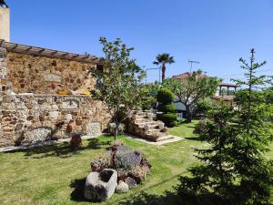 a garden with a stone wall and a tree in a yard at Thodis villa's in Karianí