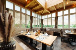 a dining room with tables and chairs and windows at Familienhotel Trebesingerhof in Trebesing