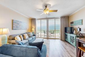 a living room with a couch and a tv at Waters Edge Condominiums in Fort Walton Beach