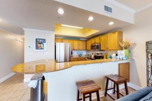 a kitchen with wooden cabinets and a counter top at Waters Edge Condominiums in Fort Walton Beach