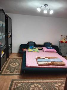 a bedroom with a bed with a pink blanket at Vila Anđelija in Velika Kladuša