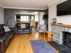 sala de estar con sofá y chimenea en Aberdauddwr en Llanwnen