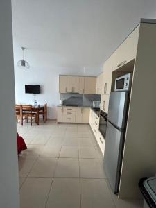 a kitchen with a refrigerator and a dining room at Grand Hotel Europa Resort Velipoje Apartment in Velipojë +6 photos