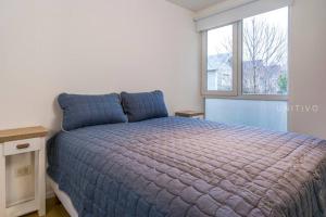 1 dormitorio con cama y ventana en Del Bosque en Ushuaia