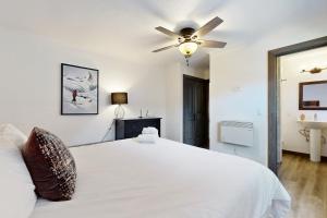 a bedroom with a white bed with a ceiling fan at Manzanita Holiday 2 in South Lake Tahoe