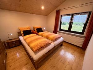 two beds in a room with a window at Ferienwohnung Lindenhof in Achslach