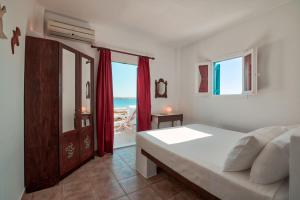 a bedroom with a bed and a view of the ocean at Glaros Studios Apartments in Antiparos