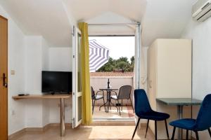 a living room with a table and chairs and a television at Apartments Andrijašević in Makarska