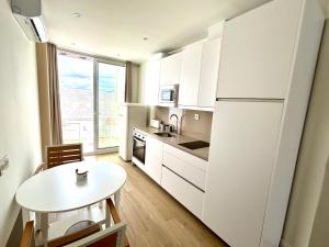 a kitchen with a table and a white refrigerator at Brand new studio apartment in Ardales