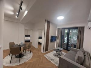 a living room with a couch and a table and chairs at Executive Suites by Modern Living in Skopje