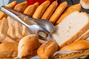 a basket of bread and utensils with sandwiches and hot dogs at Apartaments Els Llorers in Lloret de Mar