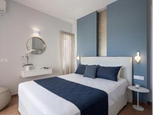 アルミリダにあるElena Apartmentsの青と白のベッドルーム(ベッド1台、鏡付)