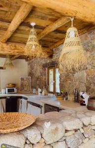een keuken met stenen muren en houten plafonds bij Résidence de Luxe 4 étoiles à Pietralba, 4 logements piscine chauffée BALAGNE in Pietralba