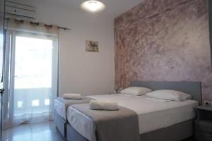 a bedroom with two beds and a large window at Galini Beach in Plakias