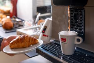 a cup of coffee and a plate with a pastry at Apartaments Els Llorers in Lloret de Mar