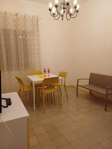 uma sala de jantar com uma mesa e cadeiras e um sofá em Soffio di Mediterraneo appartamento em Trapani