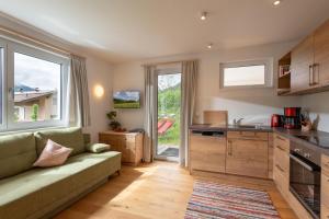 a living room with a couch and a kitchen at Appartement Naturbunt in Söll