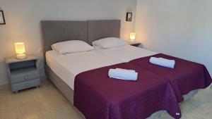 a bedroom with a large bed with two towels on it at Galini Beach in Plakias