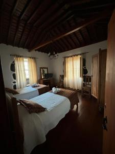 a bedroom with two beds and two windows at Casa da Madrinha Graciosa in Trás dos Pomares