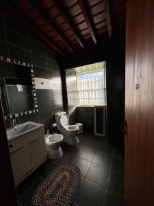 a bathroom with two toilets and a sink and a mirror at Casa da Madrinha Graciosa in Trás dos Pomares