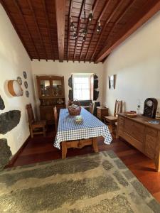 uma sala de jantar com uma mesa com uma toalha de mesa azul e branca xadrez em Casa da Madrinha Graciosa em Trás dos Pomares