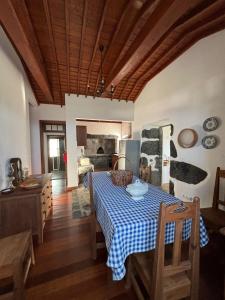 Trás dos Pomares的住宿－Casa da Madrinha Graciosa，用餐室配有一张带蓝白格子桌布的桌子