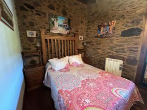 - une chambre avec un lit et un mur en pierre dans l'établissement Casal de Agra, à Bergondo