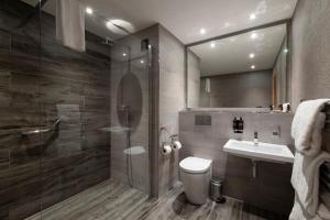 a bathroom with a shower and a toilet and a sink at The Lodge On Loch Lomond Hotel in Luss