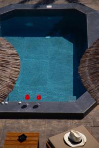 a swimming pool with a hat on a table at Rhenea Resort in Imerovigli