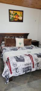 a bed with a blanket on it in a room at Hotel Colonial El Bosque in Tunja