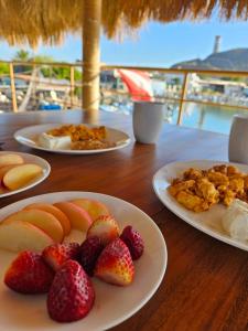 a wooden table with plates of fruit on them at Sealion Dive Center in Topolobampo