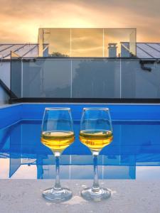 twee glazen wijn naast een zwembad bij "Golden Sky"Rooftop Pool Villa in Vodice
