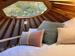 a bed in a yurt with a round window at Purple City Retreats - Luxury Yurt & Spa in Portland