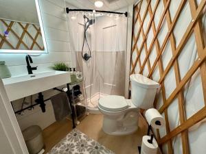 a bathroom with a toilet and a shower and a sink at Purple City Retreats - Luxury Yurt & Spa in Portland