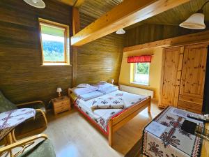 een slaapkamer met een bed in een houten hut bij Willa Rosa in Szczyrk