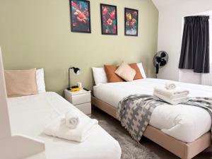 a bedroom with two beds with towels on them at Charming Studio 30min to Central London in London
