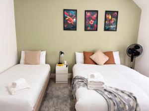a bedroom with two beds with towels on them at Charming Studio 30min to Central London in London