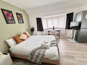 a bedroom with a large bed and a table at Charming Studio 30min to Central London in London +7 photos