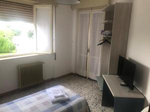 a bedroom with a bed and a desk and a television at La voglia in Villanova sullʼArda