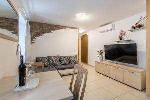ein Wohnzimmer mit einem Sofa und einem TV in der Unterkunft Luxury B&B Rooms Matusko in Split