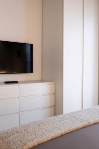 a bedroom with a tv on a white dresser at In piazza sul lago in Baveno +33 photos