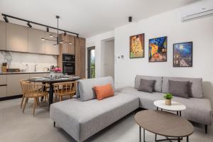 a living room with a couch and a table at Apartmani Vila Mara M 4 heated pool and whirpool in Omišalj