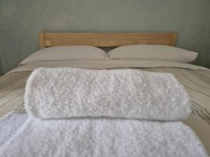 a white blanket laying on top of a bed at Wiki Hostel Colive in Zagarolo
