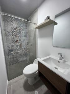 a bathroom with a toilet and a sink and a shower at Hotel Fenix in Ocaña +51 photos