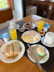 a table with plates of breakfast foods and glasses of orange juice at Hotel Tehuelche Natura in Coihaique