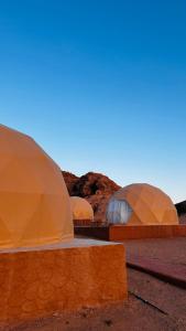 a group of three domes in the desert at wadi rum fox road camp & jeep tour in Wadi Rum
