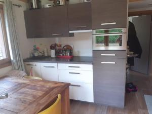 cocina con armarios blancos y mesa de madera en Appartement La Suite Mont-Blanc, en Chamonix-Mont-Blanc
