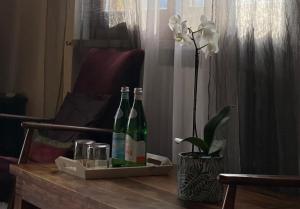 duas garrafas de vinho numa mesa de madeira com uma flor em Villa Mattei em Villa Pedergnano